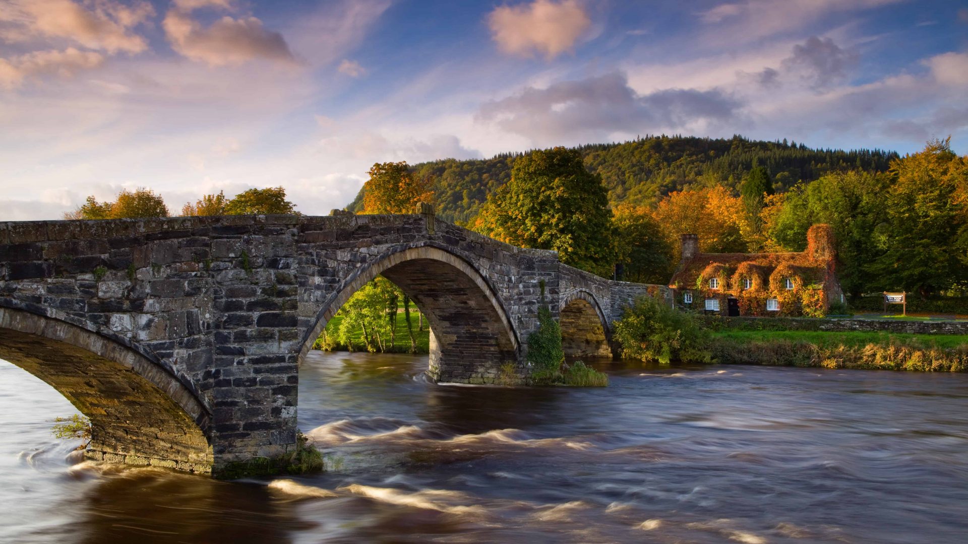VB34132970 Tu Hwnt Ir Bont, a former courthouse, and the 17th century Pont Fawr stone bridge on the river Conwy. Sunset, dusk.